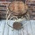 This is a very large wrought iron plant stand with a wicker (or rattan) top and a wicker shelf below. The age is certainly...