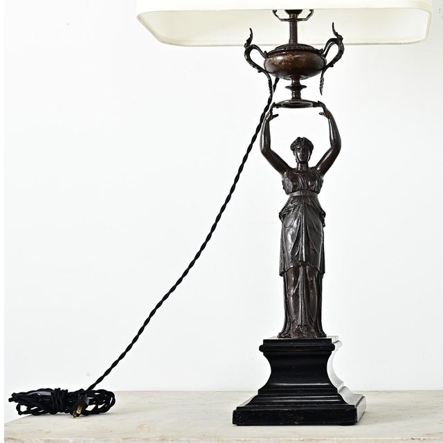 A French 19th century Empire-style cast bronze table lamp with new linen shade, this substantial Neoclassical fixture has...