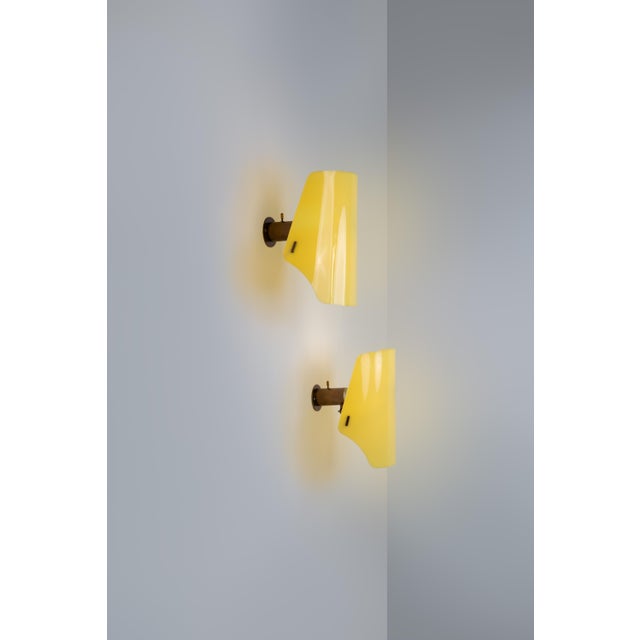 Pair of wall lamp gino sarfatti for arteluce with brass structure and yellow acrylic lampshade. The diffuser position can...