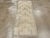 This mid-20th-century Turkish Anatolian throw rug presents a restrained geometric composition in soft ivory and pale blue-...