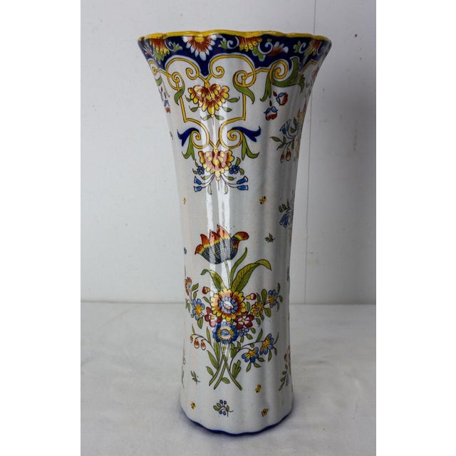 French faience vase from Rouen manufactures. Features hand painted floral decor in a blue, orange, white and yellow and...