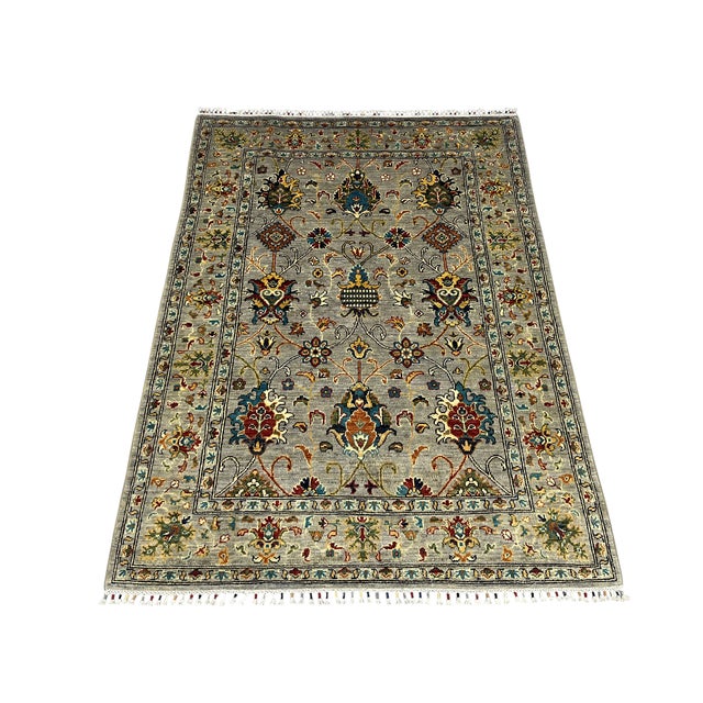 This Sultani wool rug features a Persian style botanical design with pomegranate flowers, winding vines and layered floral...