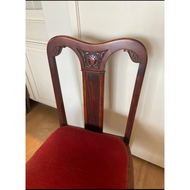 A charming antique Federal-style mahogany side chair featuring an elegant shield-inspired back, carved shell crest detail,...