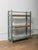 This wooden shelving unit features a straightforward, utilitarian form highlighted by its original blue-green painted...