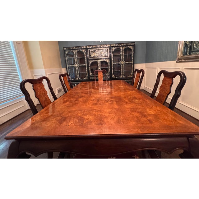 An exquisite and highly elegant seven-piece dining set featuring a magnificent dining table and six matching chairs (one...
