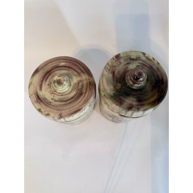 Pair of late 19th-century French provincial stoneware lidded storage jars with celadon and iron ash glazes. Originally...