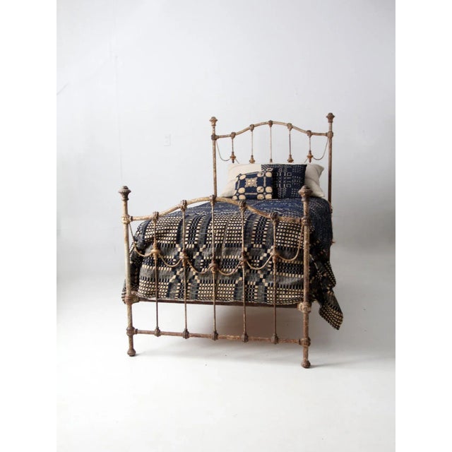An exceptional antique Victorian iron twin bed dating to the late 19th century. The headboard and footboard feature...