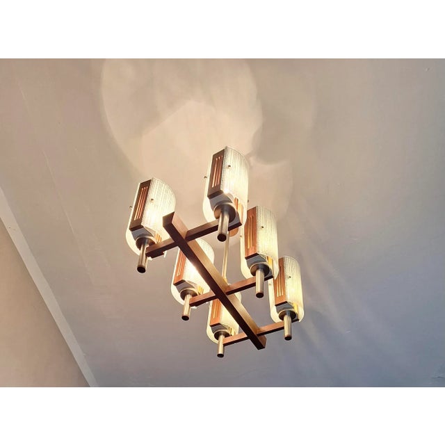 Brutalist chandelier with 6 art glass shades on a teak frame, Italy 1960s. Up to 250V (Europe/UK Standard).The wiring of...
