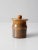 This vintage studio pottery jar is a small, handmade piece featuring a rich, variegated earthy brown glaze. The lid has a...