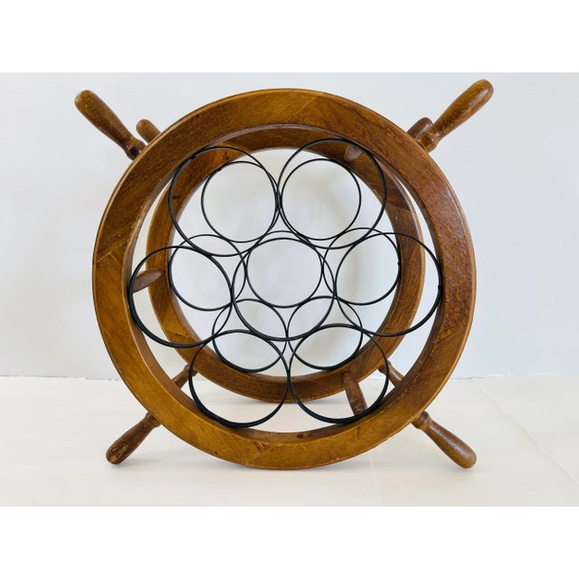 Vintage 1970s nautical style wood and black metal wine rack. The rack holds seven bottles and is made with joined wood. No...