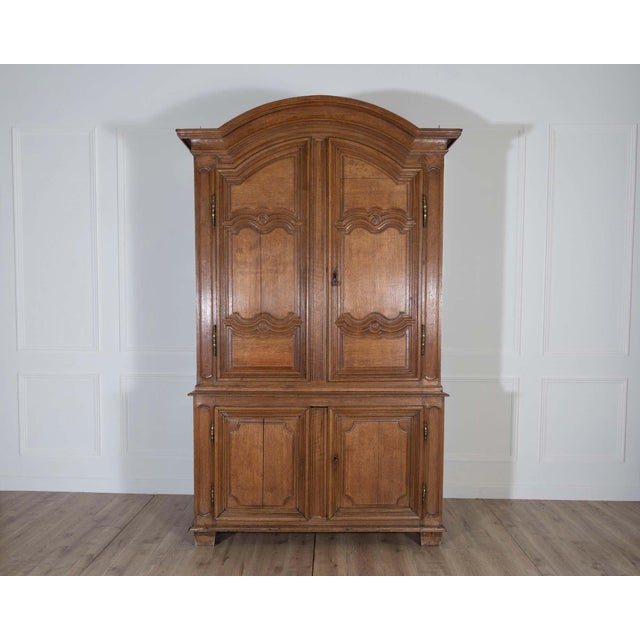Magnificent 18th-century French buffet deux corps crafted in solid blond oak with richly molded paneling and an arched...