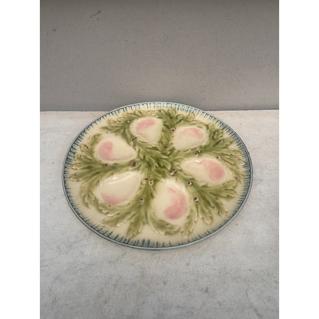 French Majolica oyster plate signed Hippolyte Boulenger Choisy-le-Roi. The six pink wells are surrounded by green seaweeds.