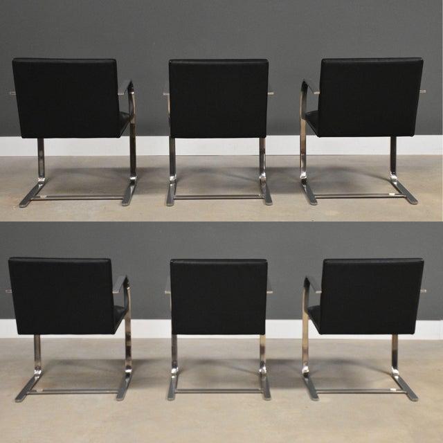 A set of six mid century modern black leather dining chairs with chrome frames designed by Mies Van Der Rohe and licensed...