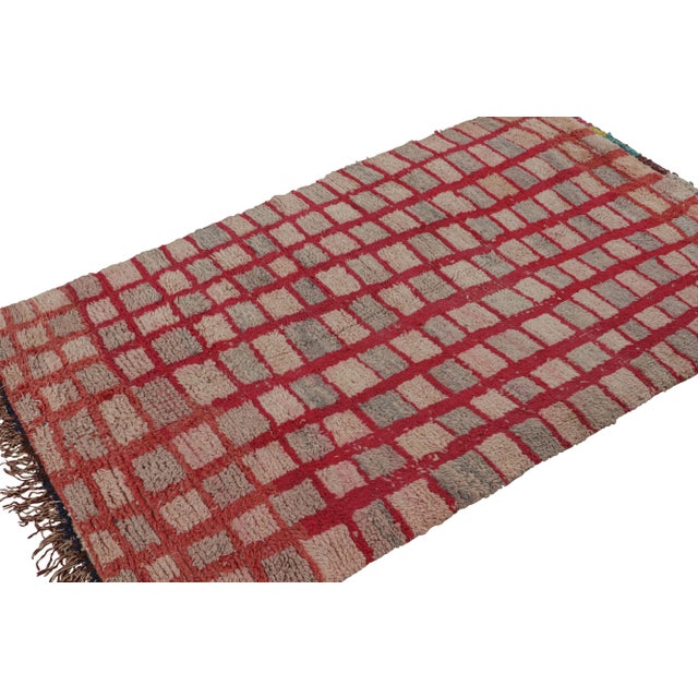 Hand-knotted in wool circa 1950-1960, this 4x7 vintage Moroccan rug with grid geometric patterns, hails from the Azilal...