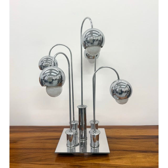 A striking postmodern table lamp in the manner of Robert Sonneman, featuring five graduated arched chrome stems supporting...