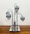 A striking postmodern table lamp in the manner of Robert Sonneman, featuring five graduated arched chrome stems supporting...