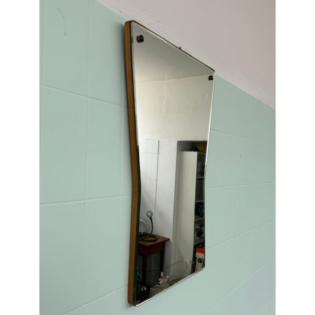 This vintage mirror features a slightly trapezoidal shape with gently rounded corners. The thin frame leaves ample space...