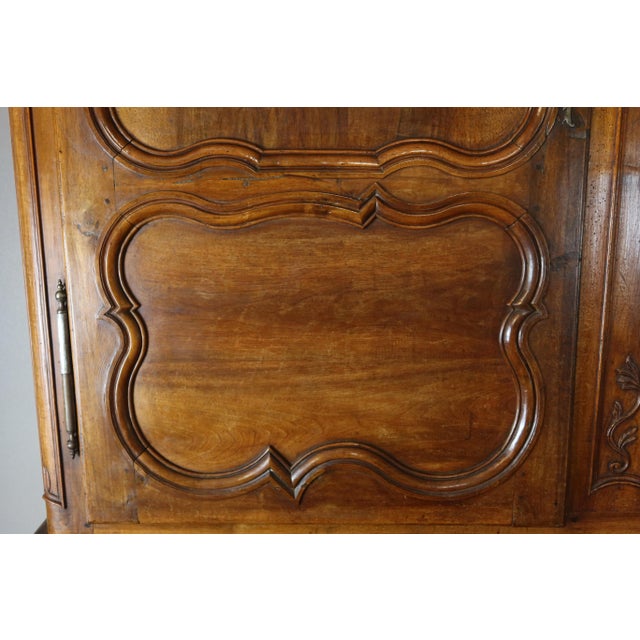 A two-part Louis XV style walnut buffet, 18th century. This two-part piece features three doors and a drawer in the lower...