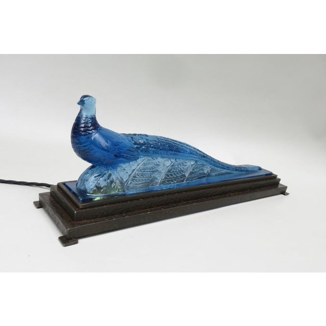 An impressive table lamp "Pfau", made by Verlys France from the time of Art Deco. The peacock, designed in blue glass, is...