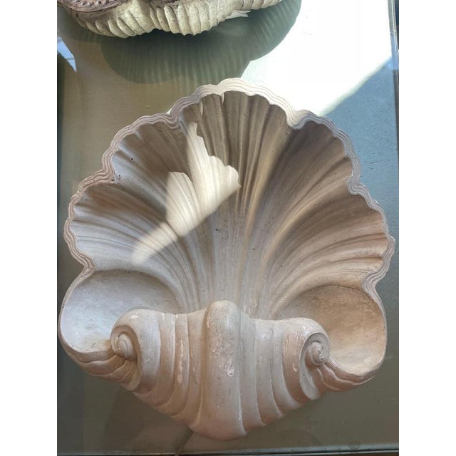 Wall lamp with a unique shell-shaped design made of plaster. The shell has a space underneath to hold the cable and bulb,...