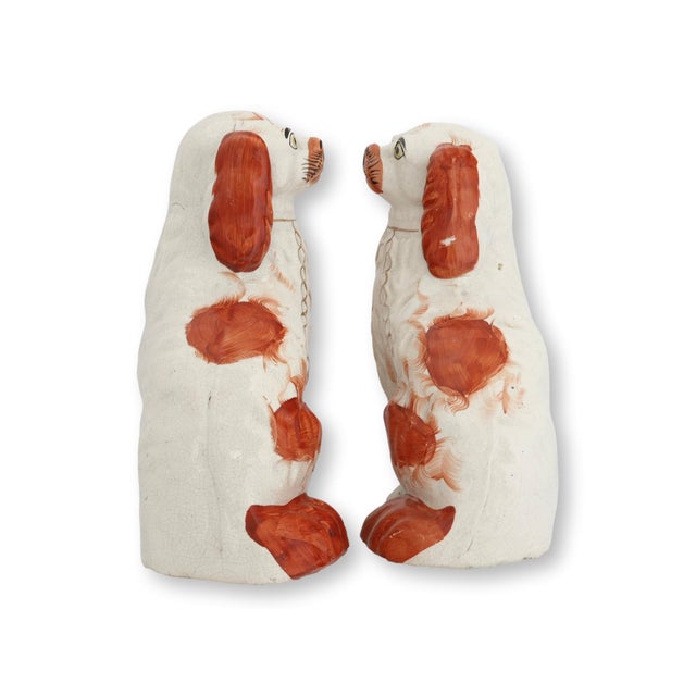 Mid 19th century pair of English Staffordshire King Charles dogs featuring classic hand-painted decoration and traditional...