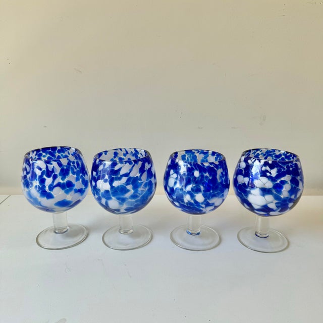 Vintage set of four blown blue tortoiseshell patten large glass goblets. Each glass has a rich cobalt blue and white...