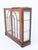 A stylish Art Deco walnut display cabinet, standing on a shaped plinth base and exhibiting the clean lines and elegant...
