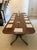 An antique English figured mahogany extending dining table in the Regency style built as a twin pillar design and seating...