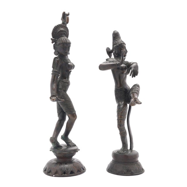 Pair of cast and patinated bronze figures of Parvati & Shiva, shown in dancing poses on shallow lotus plinths. Tamil Nadu,...