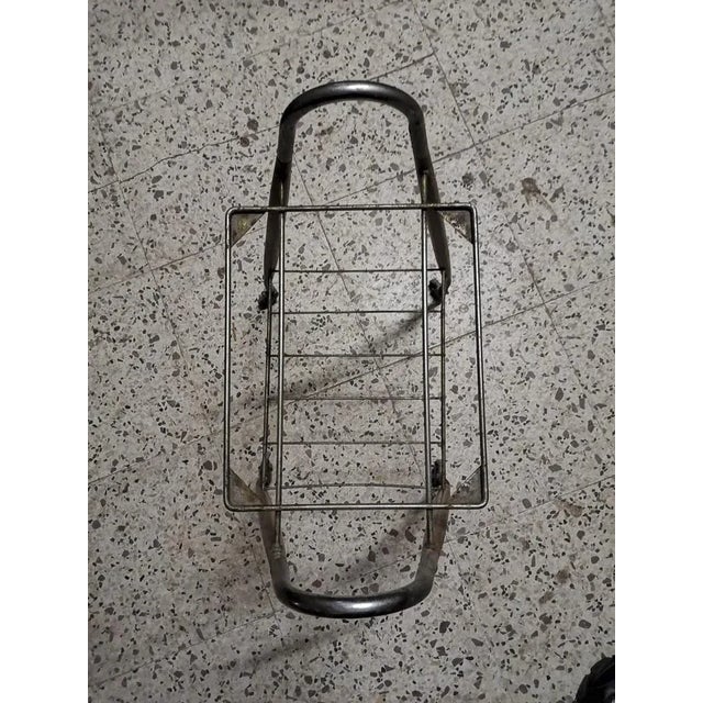 Tv stand and magazine rack in chromed and painted metal with two shelves missing the glass, equipped with wheels for easy...