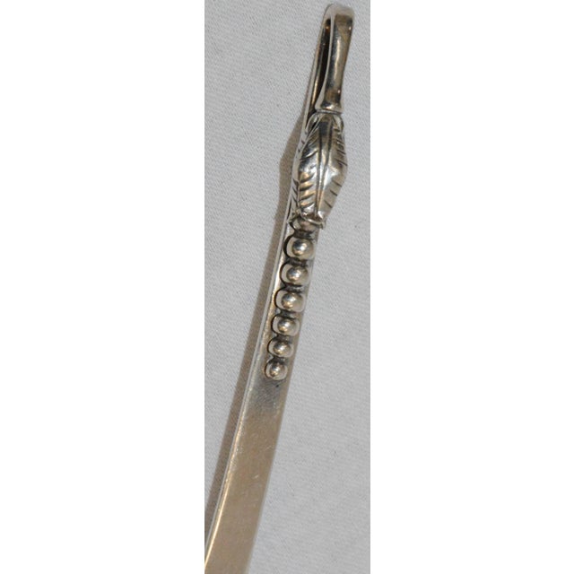 This is a nice, vintage Sanborns sterling silver ladle. The piece feature a curved double handle with a leaf and beaded...