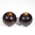 A pair of antique lignum vitae bocce lawn bowling balls (4.5” diameter) in dark stained wood with small circular inset...