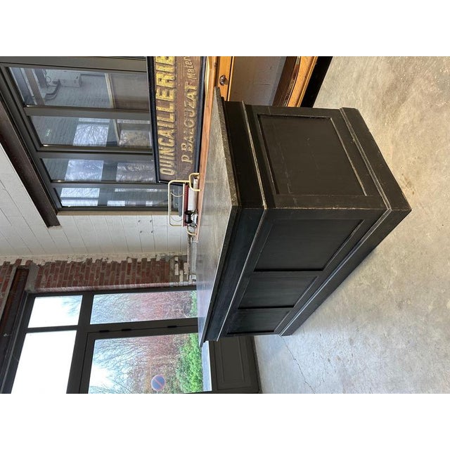 Cet ilot de magasin début XXème a été entièrement restauré Il se compose d’un corps de meuble en sapin patiné noir et d’un...