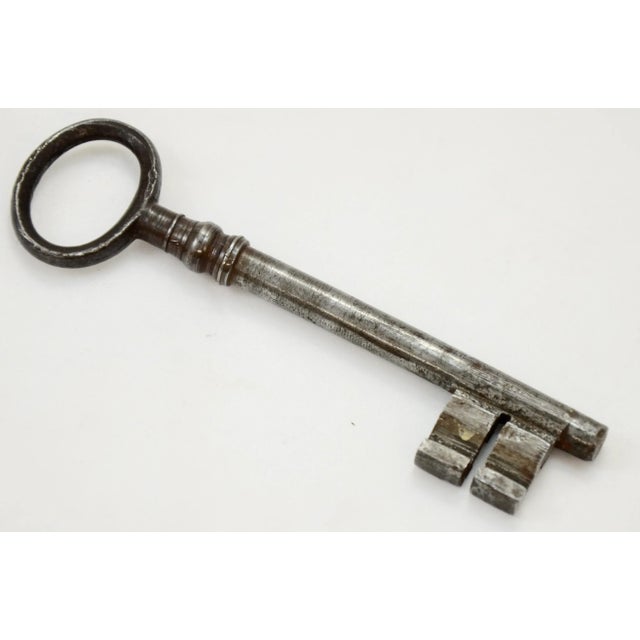 Large four inch antique European steel gate or chateau skeleton key with harp head and well-defined teeth attached to a...