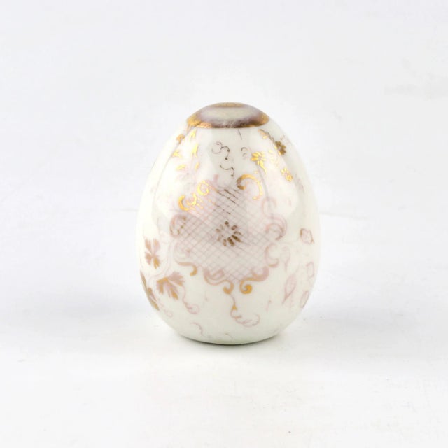 A porcelain Easter egg with a painted Raphael angel, golden vignette and decorative garlands. 1900s. Presumably the...
