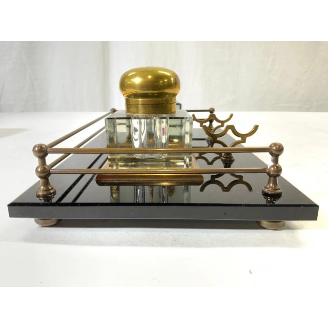 An antique double inkstand with a rectangular black marble or black glass base with two square crystal inkwells on brass...