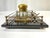 An antique double inkstand with a rectangular black marble or black glass base with two square crystal inkwells on brass...