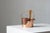 A cylindrical vessel made of polished copper, with a transparent glass insert set inside. The body is complemented by a...