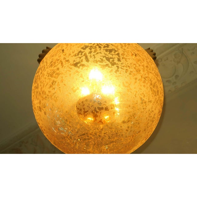 Impressive brass and frosted glass globe pendant from the 1970s from Doria Leuchten. 3 lights hang freely suspended inside...