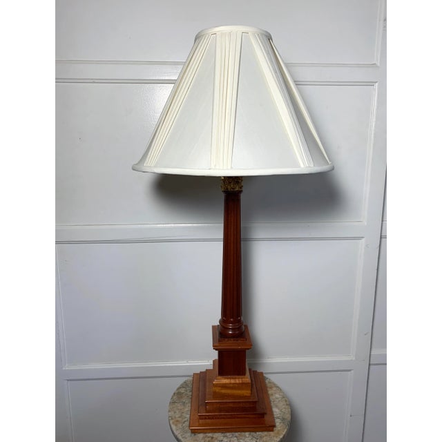 This David Linley walnut table lamp has a cast bronze capital topping a fluted & tapering Corinthian column and is...
