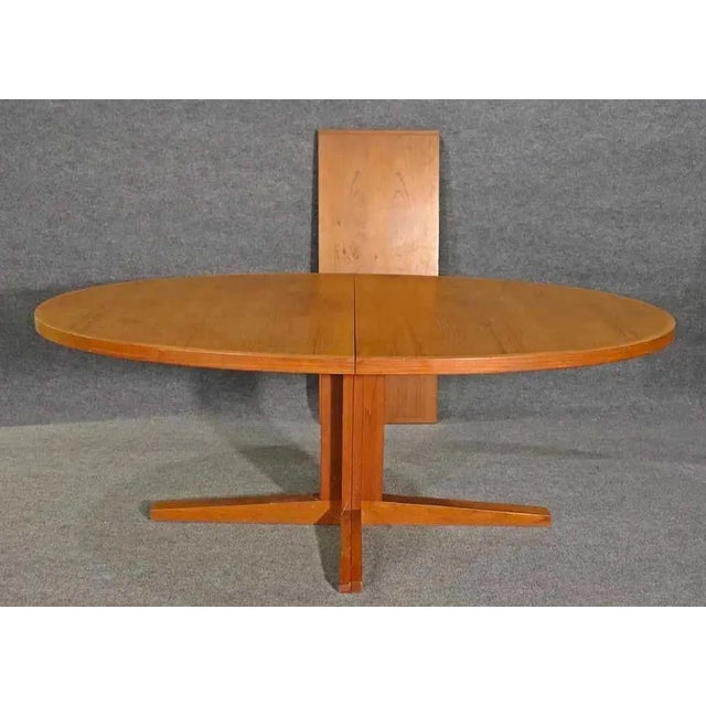 Long Danish dining table in teak wood with 19" leaf. Designed by John Mortensen for Heltborg Mobler. Simple design with...