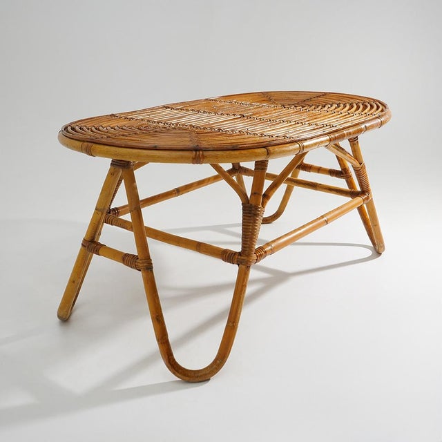 A 1950s wicker coffee table that naturally reflects the period's appreciation for light, informal furnishings designed to...