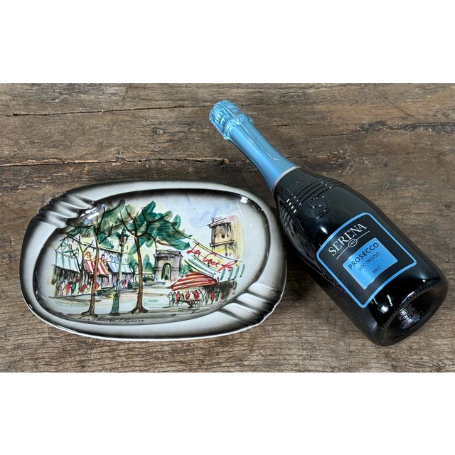 Mid 20th century French oval ceramic dish featuring a hand-painted Paris street scene labeled Les Champs-Élysées, with Arc...