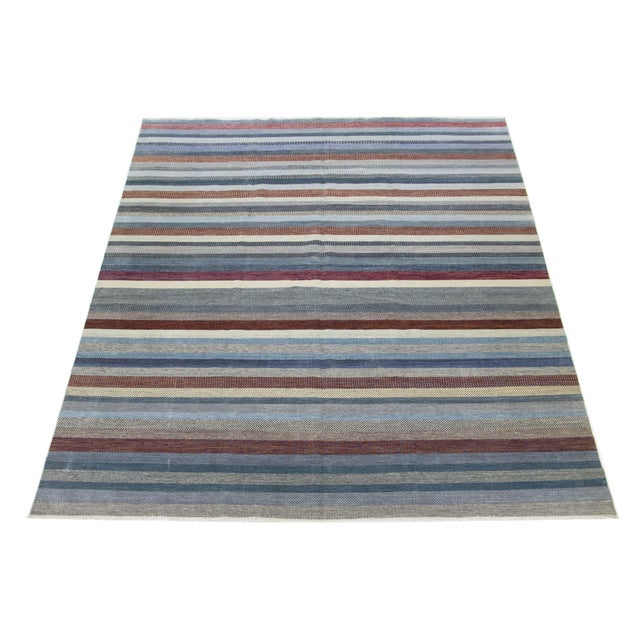 This beautifully hand-knotted wool rug features a modern design. It showcases a carefully crafted field in shades of gray,...