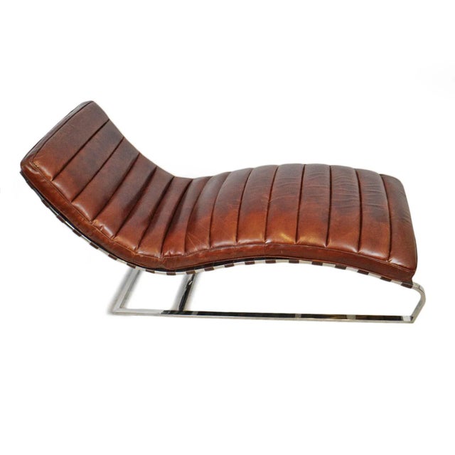 Sculptural handsome chaise lounge rich chestnut-toned leather with a sleek polished chrome frame in a form that feels both...