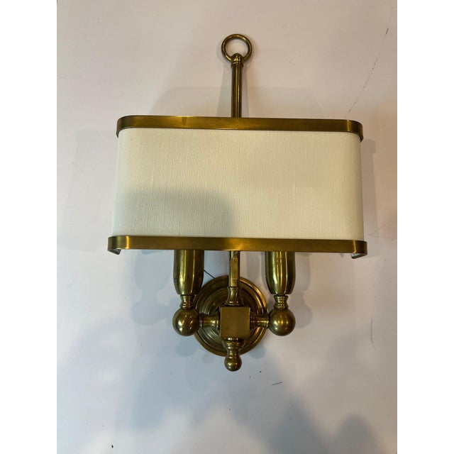 An elegant and exceptionally well-preserved, unused pair of Italian brass two-light wall sconces. Distinguished by their...