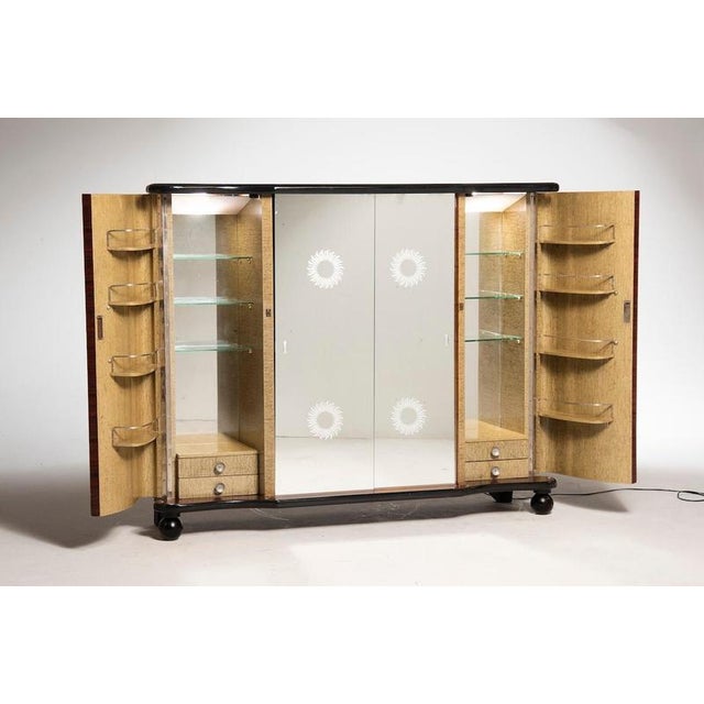 Italian Art Deco bar cabinet in walnut with burlwood interior. The cabinet features two side doors fitted internally with...