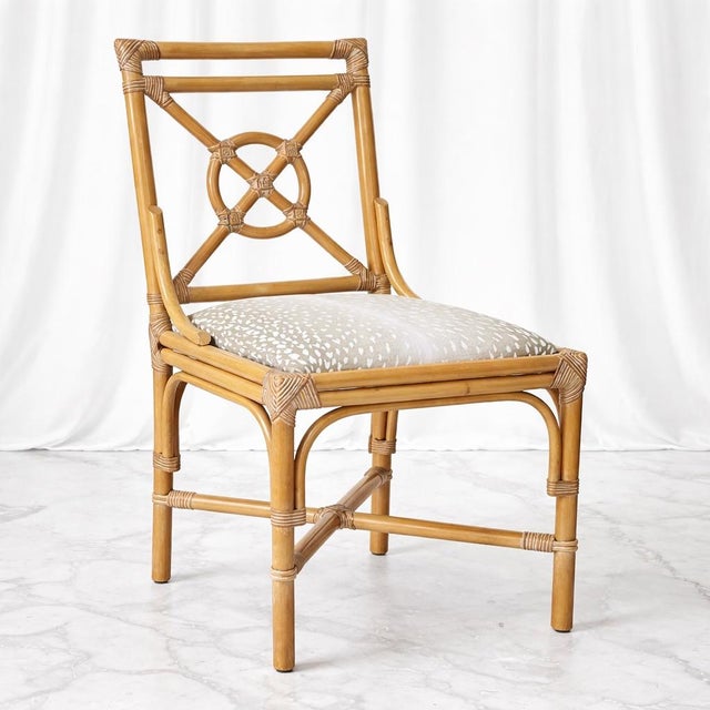 An elegant set of six French rattan dining chairs, crafted in the manner of McGuire and distinguished by their sculptural...