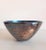 The silvered bowl is cloudy and shows a multi-layered patina that contrasts with the clean shiny enameling of the inside....