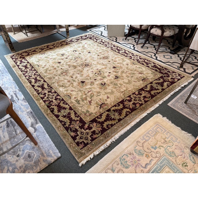 Design Plus Gallery presents a 7ft 10in x 9ft 11in Area Rug. The rug has a thick, deep plum border with brightly toned...